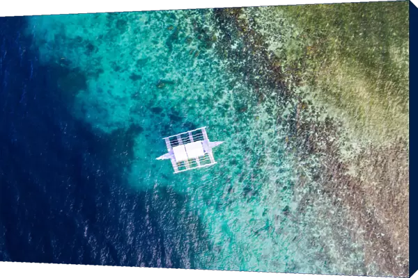 Aerial view of outrigger boat and coral reef, Philippines