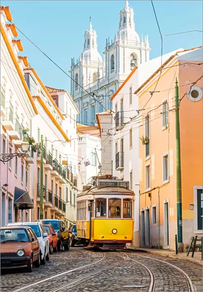 Yellow tram on the narrow street of Alfama district in Lisbon, Portugal