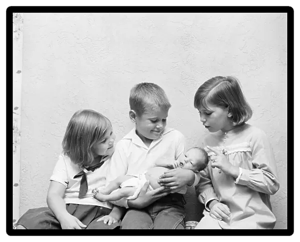 Brother holding baby sister, two sisters looking