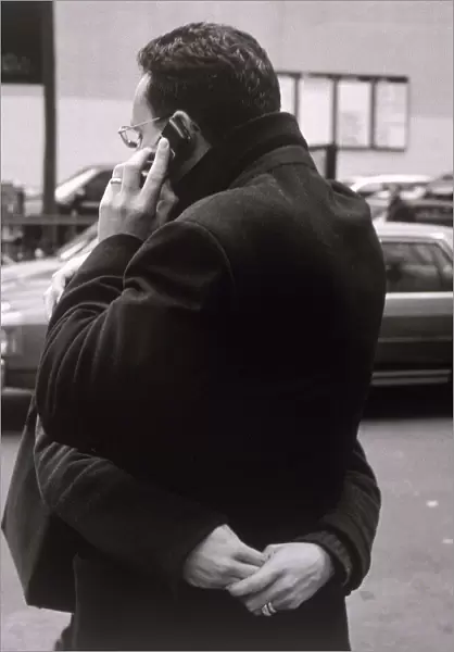 Man talking on cell phone and hugging woman