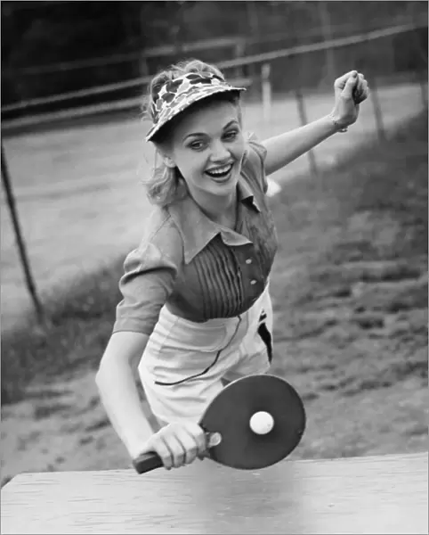 Woman playing table tennis, (B&W)