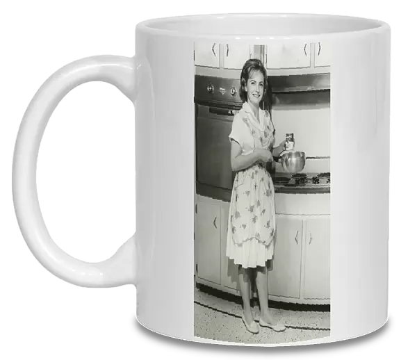 Young woman holding can of soup and pot in kitchen, (B&W)
