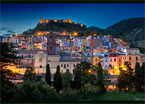 Nighttime view over the colourful town of Bosa and its medieval castle along the Temo