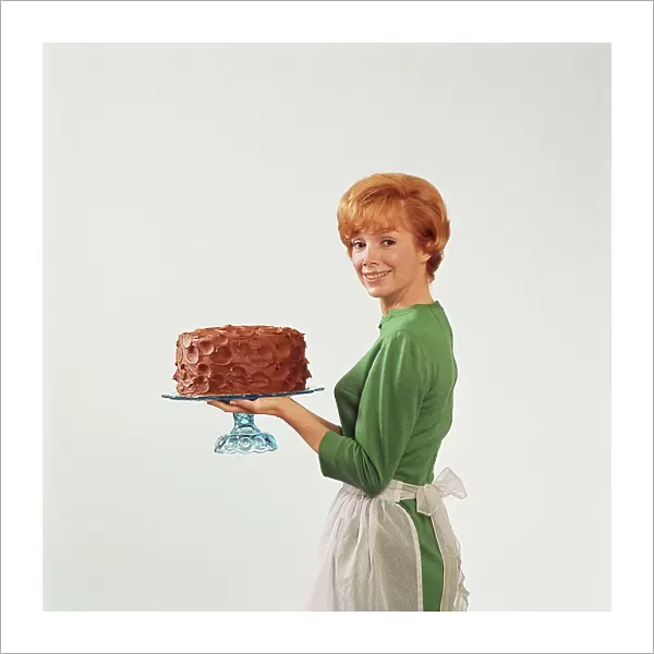 Woman holding cake, smiling, portrait