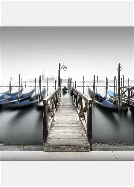 Minimalist long exposure of the gondolas at the Piazzetta near the Campanile at St. Mark's Square in Venice, Italy