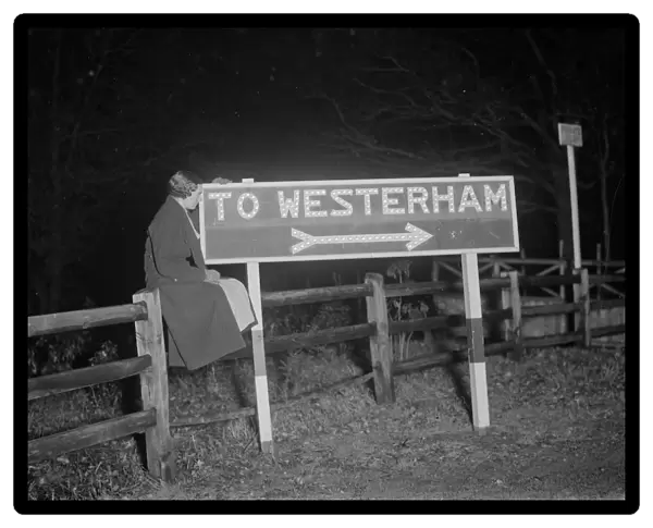 Westerham road sign lit up at night. 1936