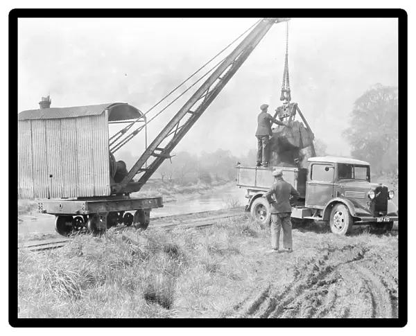 Loading sand into a lorry with a crane. 1935