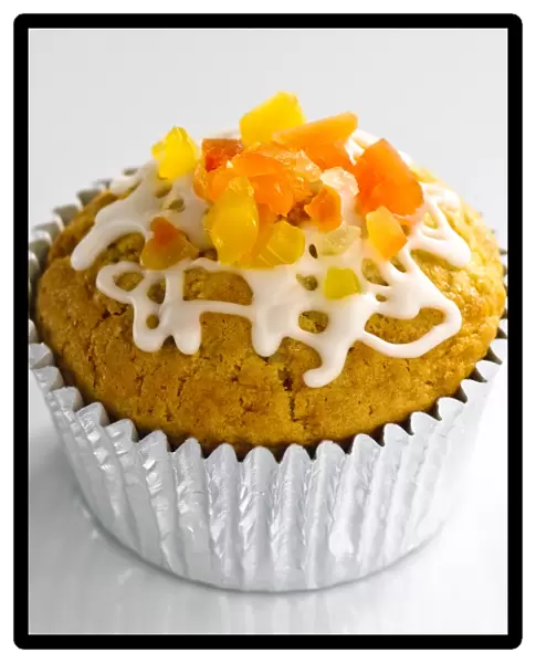 Sweet muffin in foilcase topped with candied fruit and icing trails credit: Marie-Louise