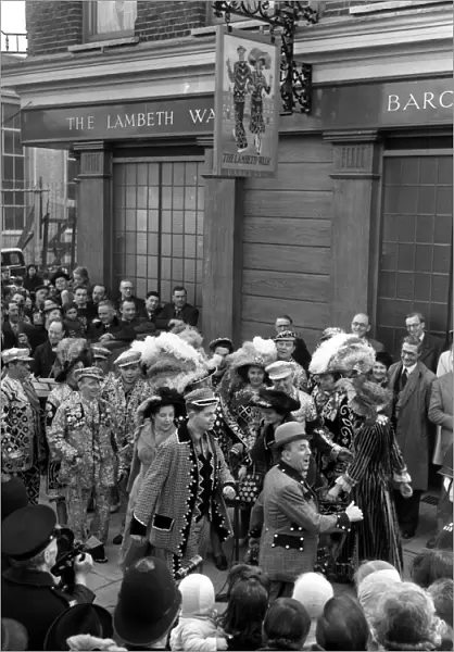 Under the sign of Lambeth Walk public house, actor Lupino Lane ( in bowler hat )