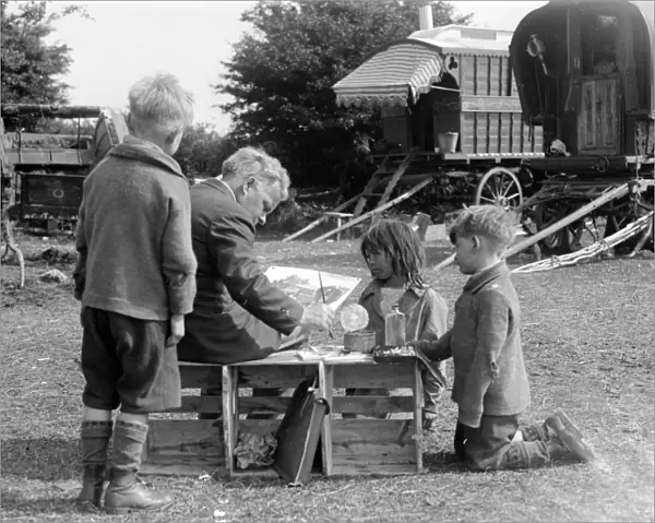 Gypsy children watching a man painting their caravan camp on Epsom Downs, Surrey