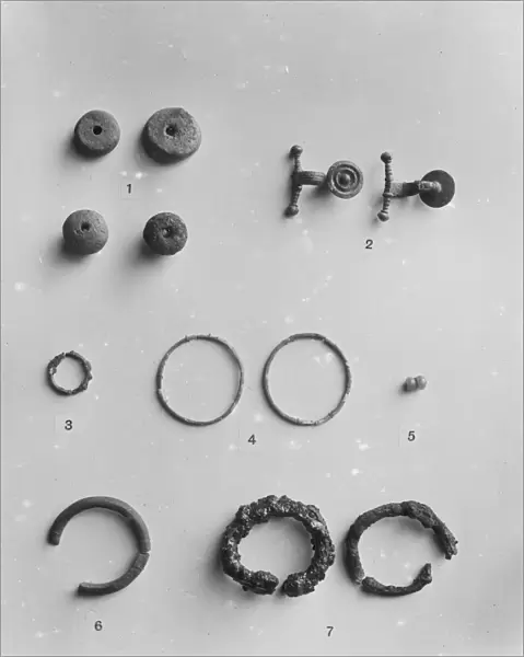 Spindle whorls, Iron Age brooches and various rings from the Iron Age cemetery at Harlyn Bay, St Merryn, Cornwall. 1900