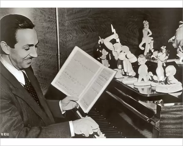 Walt Disney plays piano to a group of figures of Disney characters, c. 1940 (b  /  w photo)
