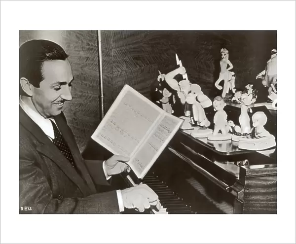 Walt Disney plays piano to a group of figures of Disney characters, c. 1940 (b  /  w photo)