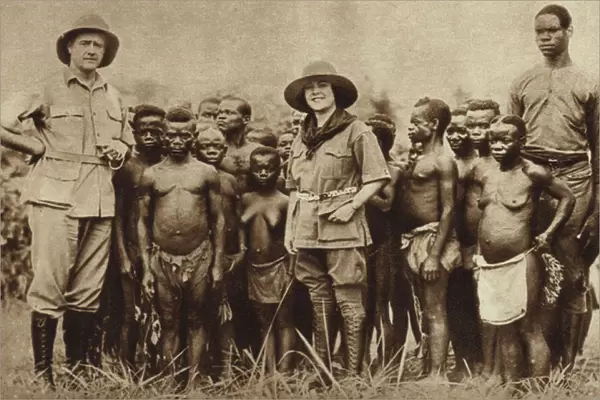 American explorer and his wife with a group of African Pygmies in the Belgian Congo (b  /  w photo)