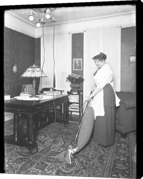 Unidentified woman demonstrating the use of the Apex vacuum cleaner, c