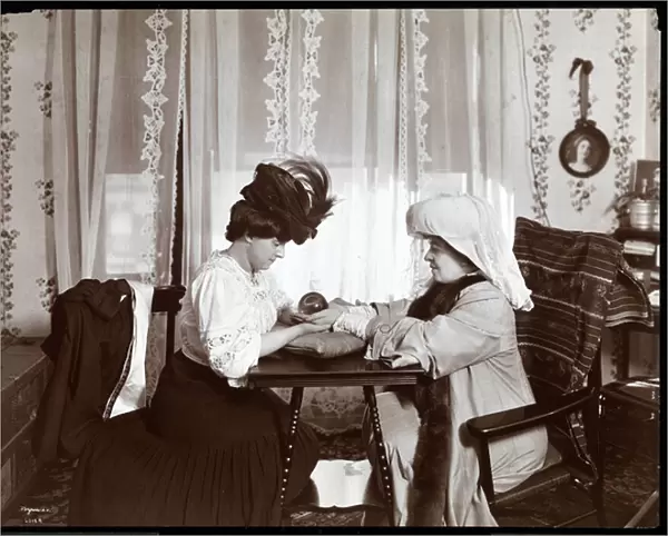 Mrs. Leslie Carter seated with a woman reading a crystal ball