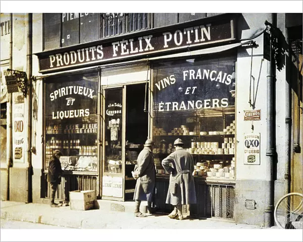 Two French soldiers and a boy in front of the liquor store Felix Potin at the market