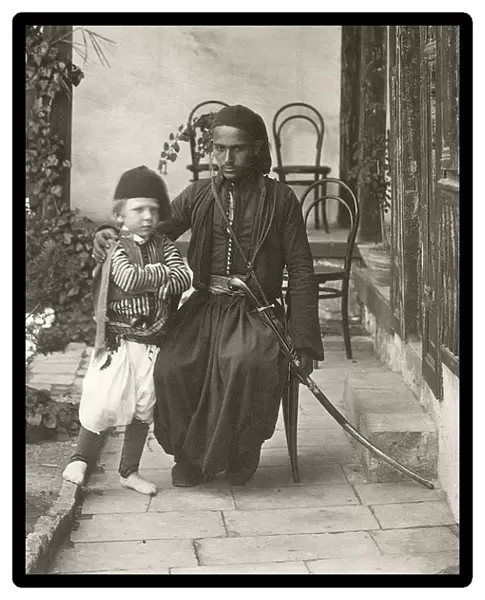 Arab kawass (Ottoman guard) with a young boy in the garden of a house in the Judea