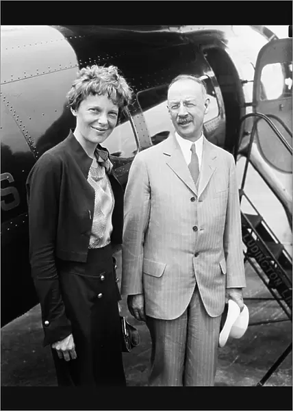 Amelia Earhart (L), Portrait with Man in front of Airplane, 1932 (b / w photo)