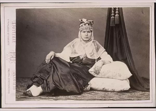 Algerian woman seated floor arm resting cushions