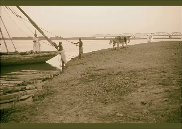 Men boat shores Nile River Omdurman Bridge background