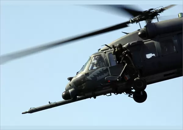 An aerial gunner waves goodbye from an HH-60G Pave Hawk