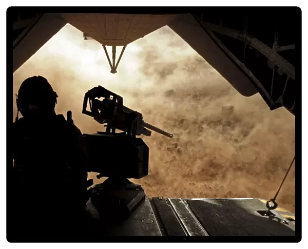A Marine waits for dust to clear while sitting on a CH-53 Super Stallion