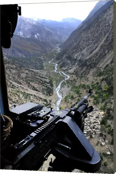 An aerial gunner surveys the surrounding area during a combat mission in Afghanistan