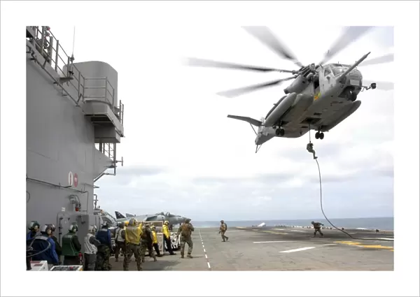 Marines and sailors fast-rope from a CH-53E Super Stallion