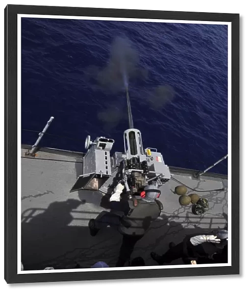 Gunner fires a Mark 38 machine gun aboard USS Frank Cable