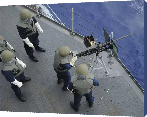 A U. S. Sailor fires a. 50-caliber M2HB machine gun aboard USS Frank Cable