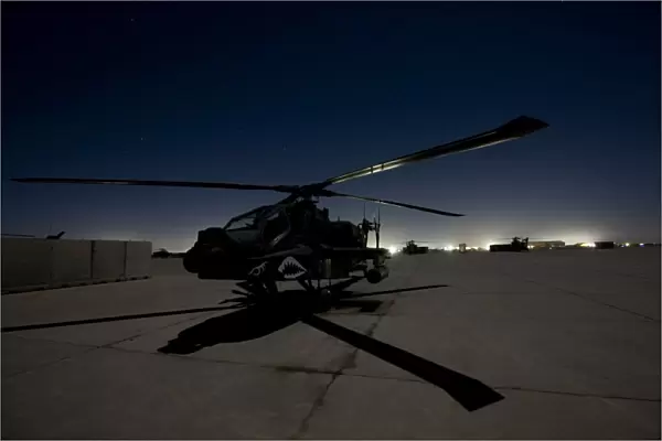 An AH-64D Apache Longbow Block III on the flight line at night