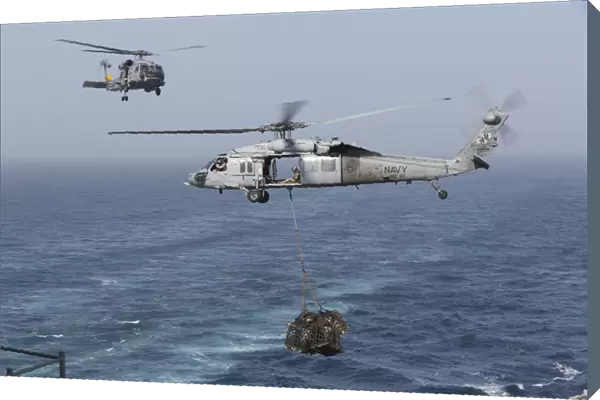 A MH-60S Knighthawk transfers cargo during a vertical replenishment