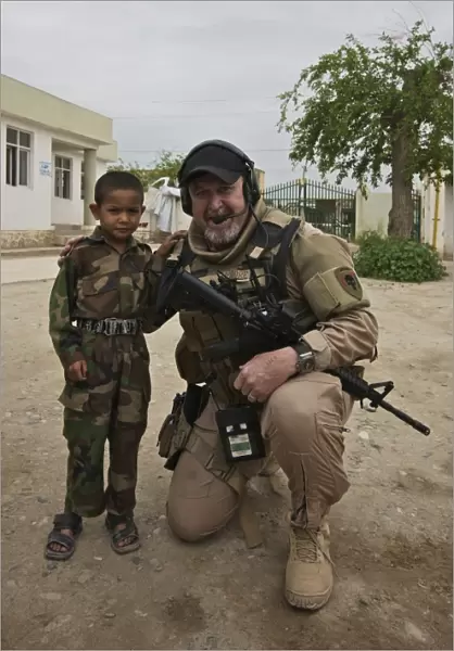 U. S. Contractor poses for a picture with an Afghan child