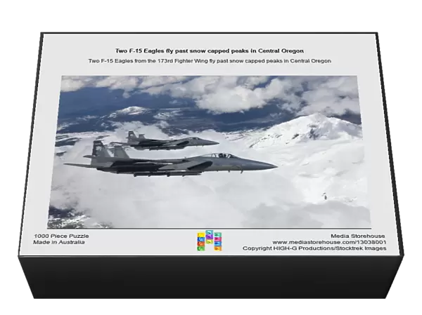 Two F-15 Eagles fly past snow capped peaks in Central Oregon