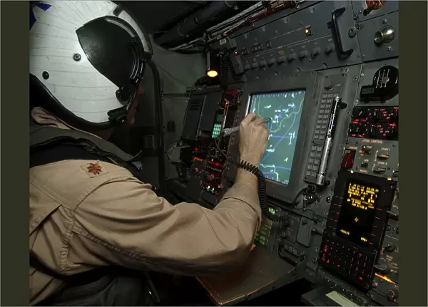 A Naval Flight Officer tracks aircraft at his station on an E-2C Hawkeye