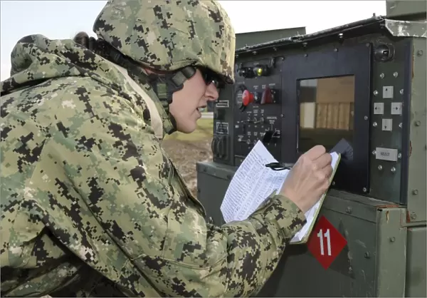 Seabee completes a generator check during a Command Post Exercise