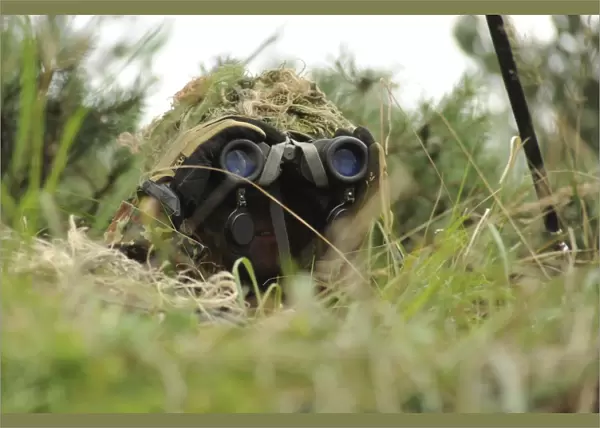 A German Bundeswehr soldier camouflages himself to blend into his surroundings