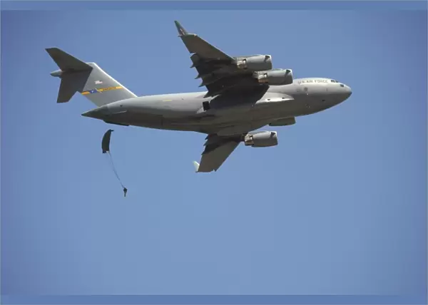 A U. S. Army paratrooper parachutes from a C-17 Globemaster III cargo aircraft