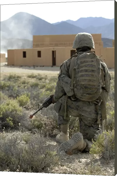 A U. S. Marine watches for simulated insurgents in a military operation on urban terrain