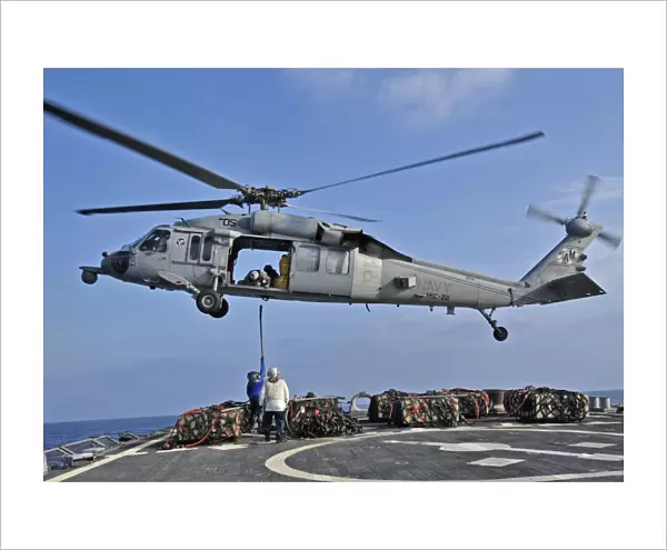 Sailors attach a cargo pennant to a MH-60S Sea Hawk helicopter
