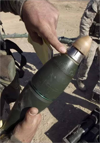 A squad leader points to a delay setting on an 81mm mortar round