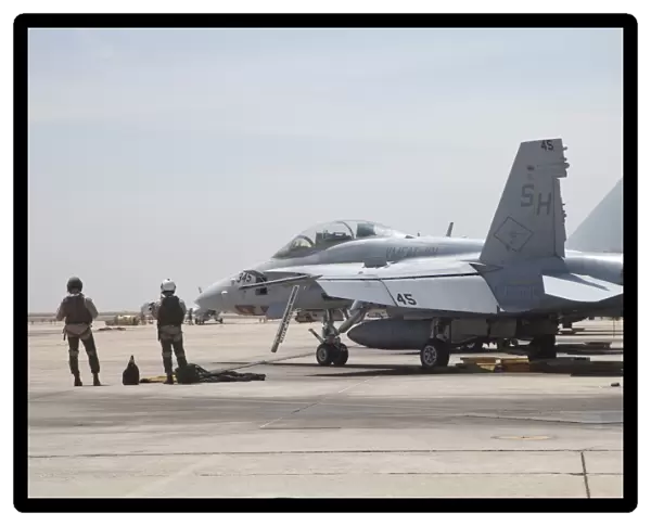 Pilots wait to board their F  /  A-18B Hornet trainer aircraft