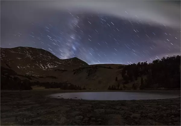 Star trails and the blurred band of the Milky Way above a lake in the Eastern Sierra