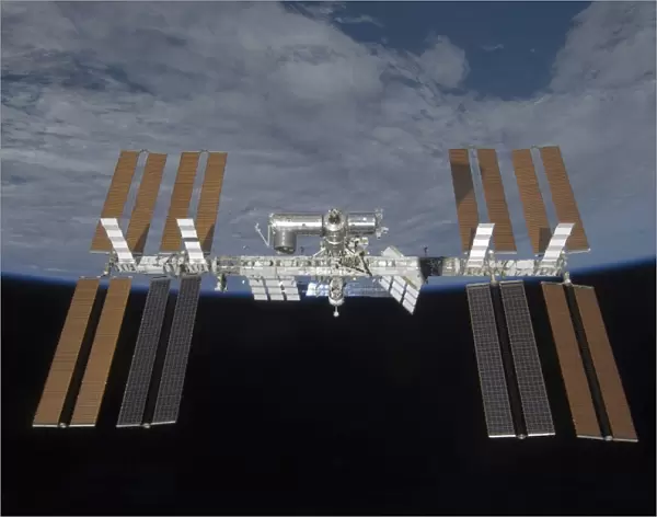 The International Space Station, backdropped by the blackness of space and Earth s
