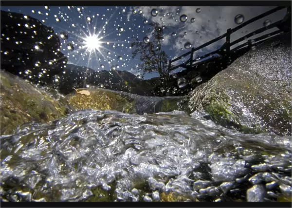 A split-level image of a mountain stream, in autumn, with water droplets on lens