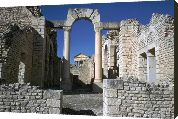 Distant Roman capitol of Dougga seen through an arch, 2nd century