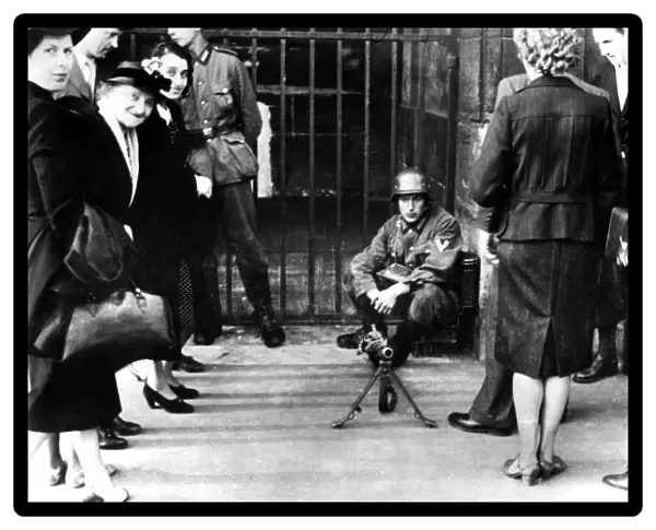 Civilians in front of a German guard post with a machine gun, Paris, June 1940