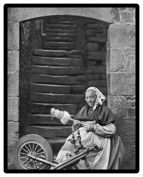 A woman at a spinning wheel, Dinan, Brittany, France, c1922