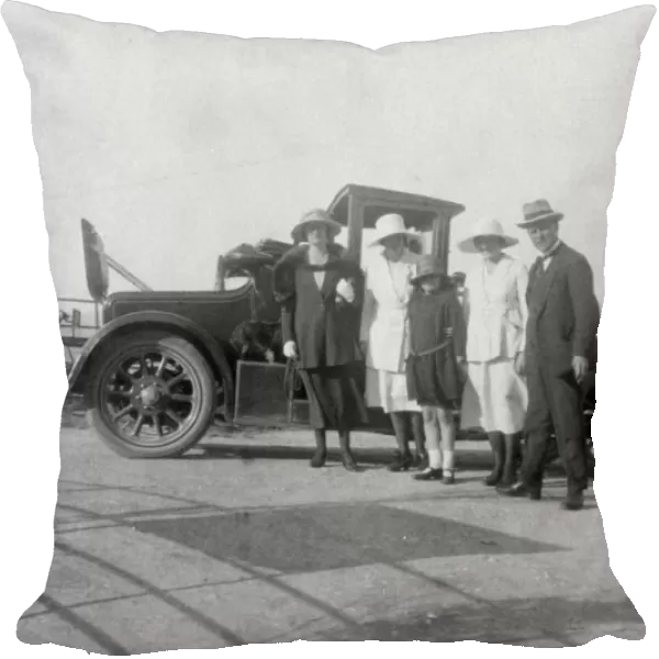 A group of people in front of their car at the seaside, c1920s(?)